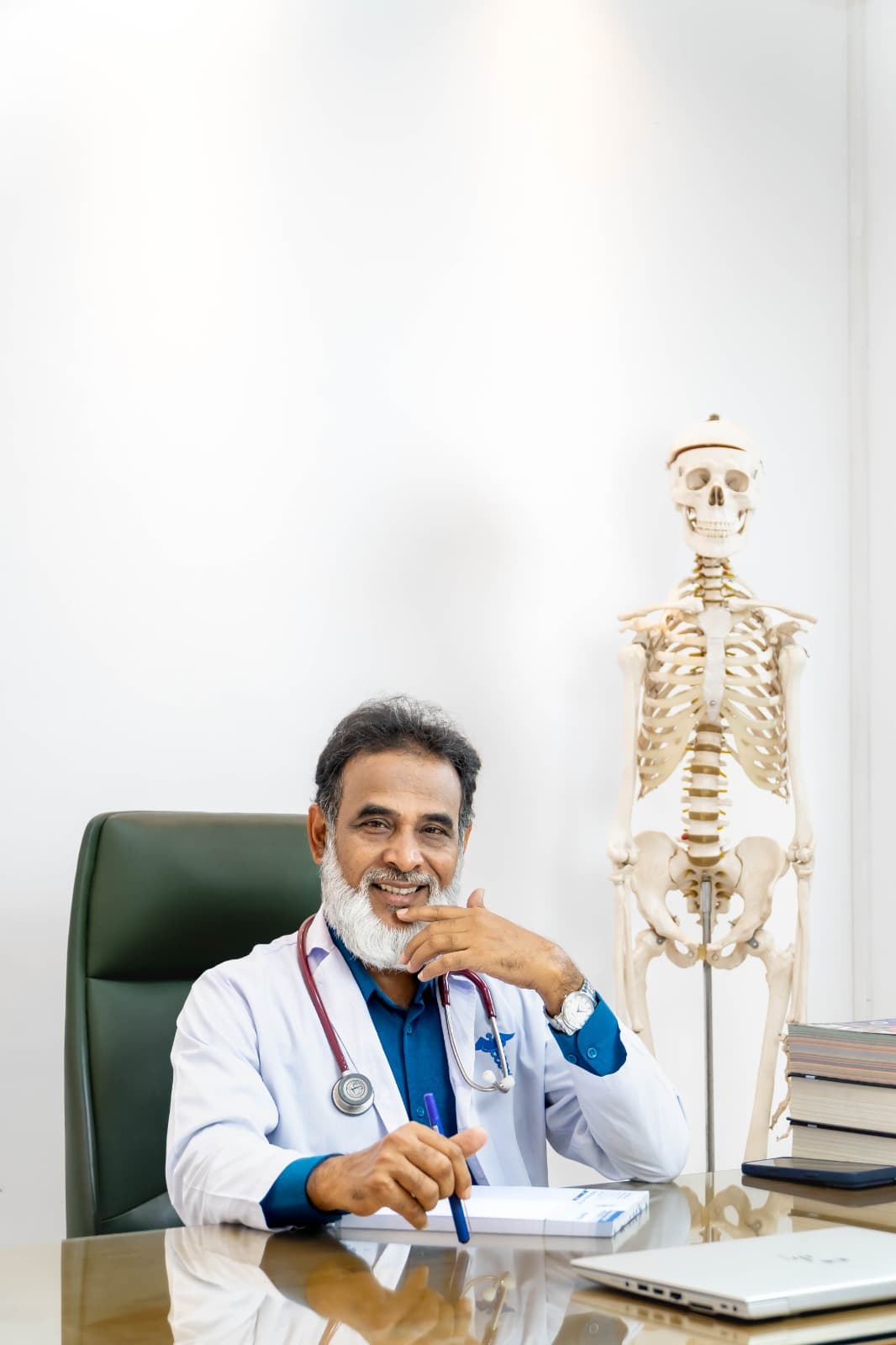 Professional portrait of Dr Shah Alam consulting a patient